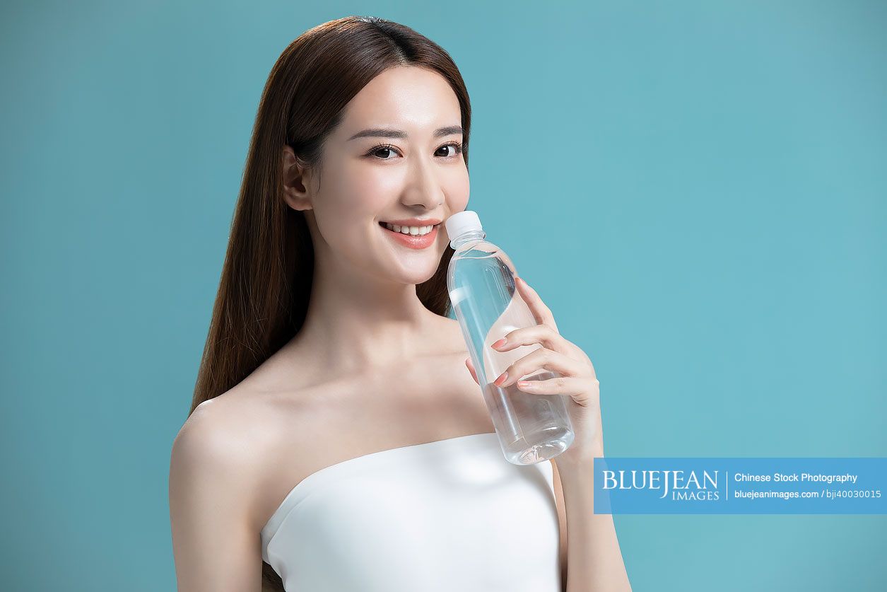 Beautiful young Chinese woman holding a bottle of water