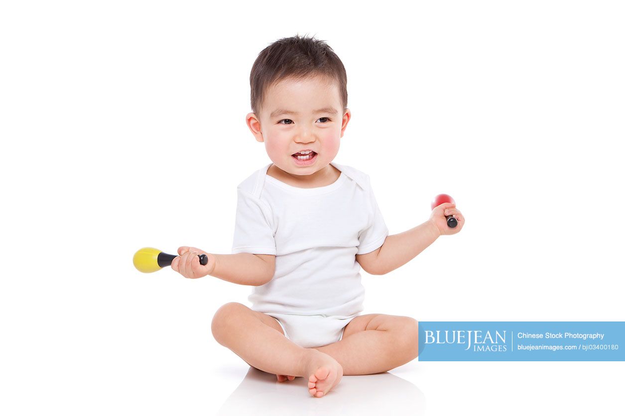 Happy Chinese baby boy with toy microphone