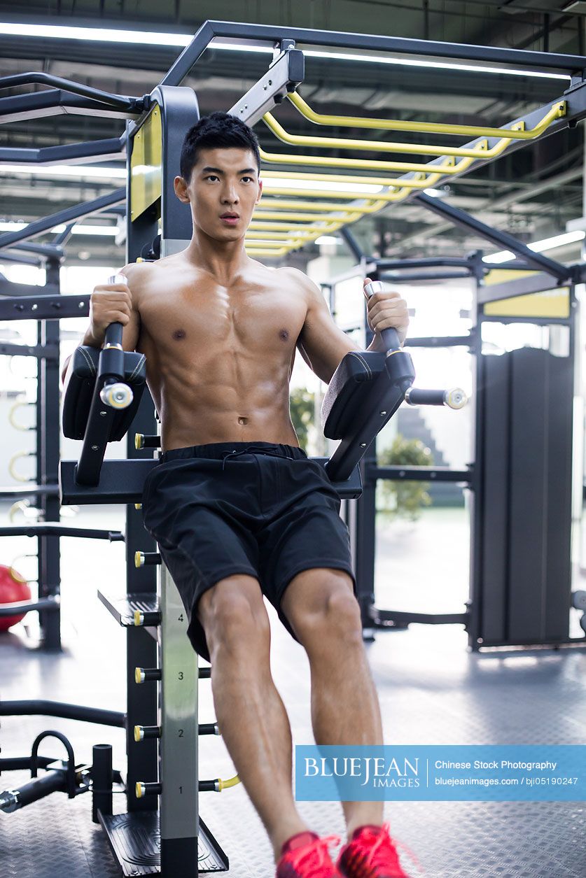 Young Chinese man exercising at gym