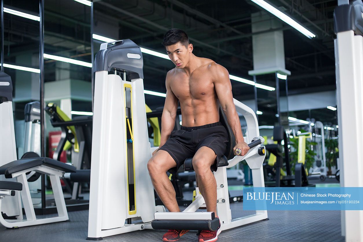 Young Chinese man exercising at gym