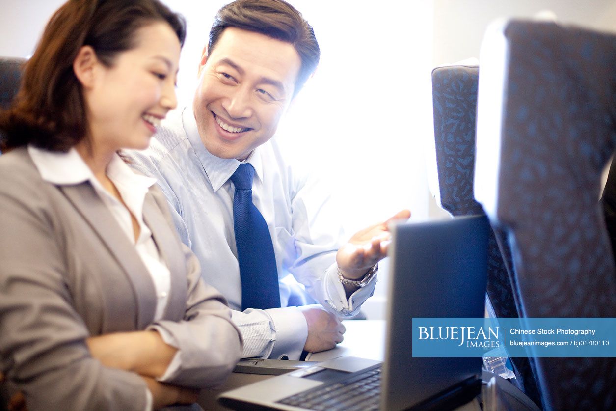Chinese businesspeople working on the plane