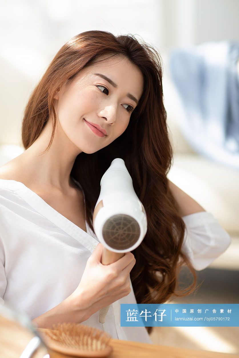 年轻女士在家吹头发