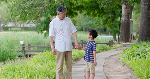 Happy Chinese grandfather and grandson walking in park,4K