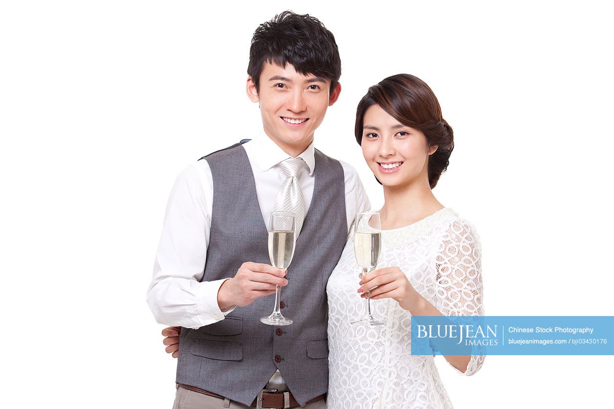 Happy young Chinese couple having champagne