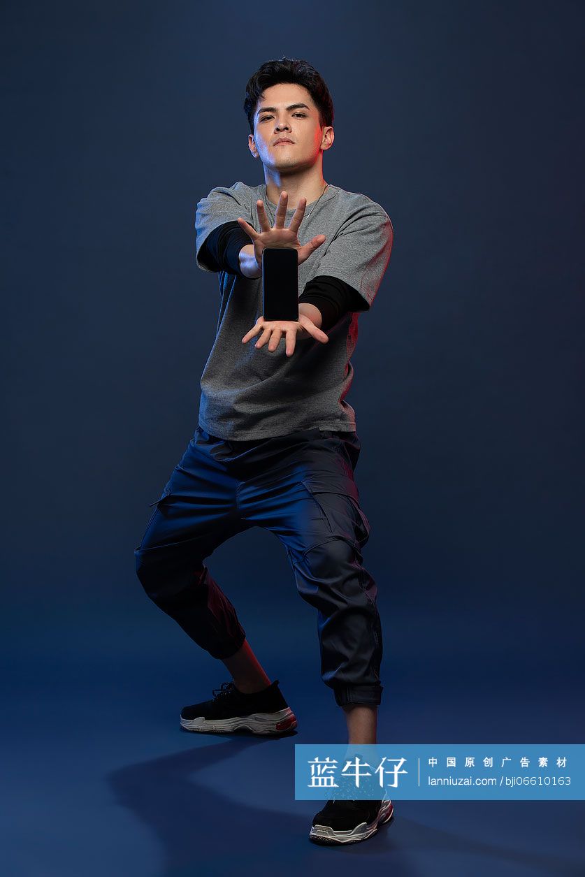 时尚的年轻男子展示手机