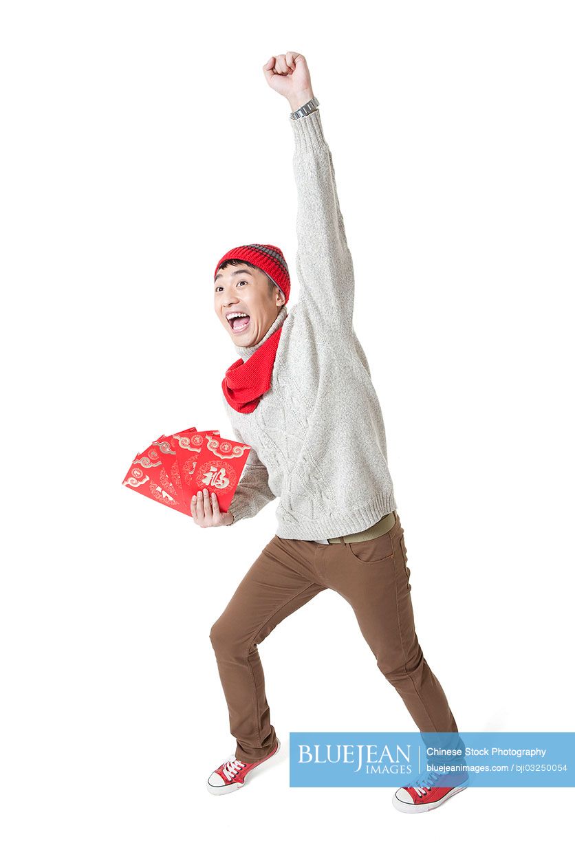 Excited young man celebrating Chinese New Year with red envelops