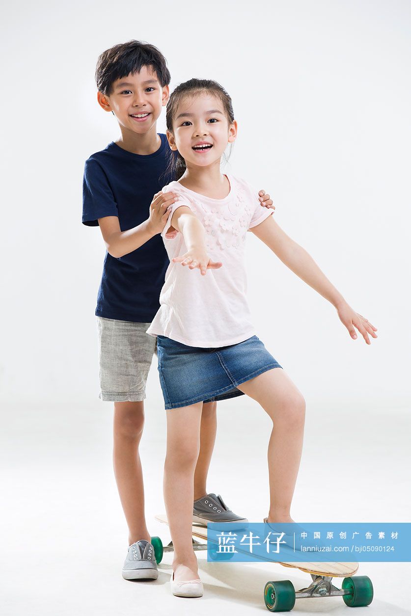 可爱的小男孩和小女孩玩滑板