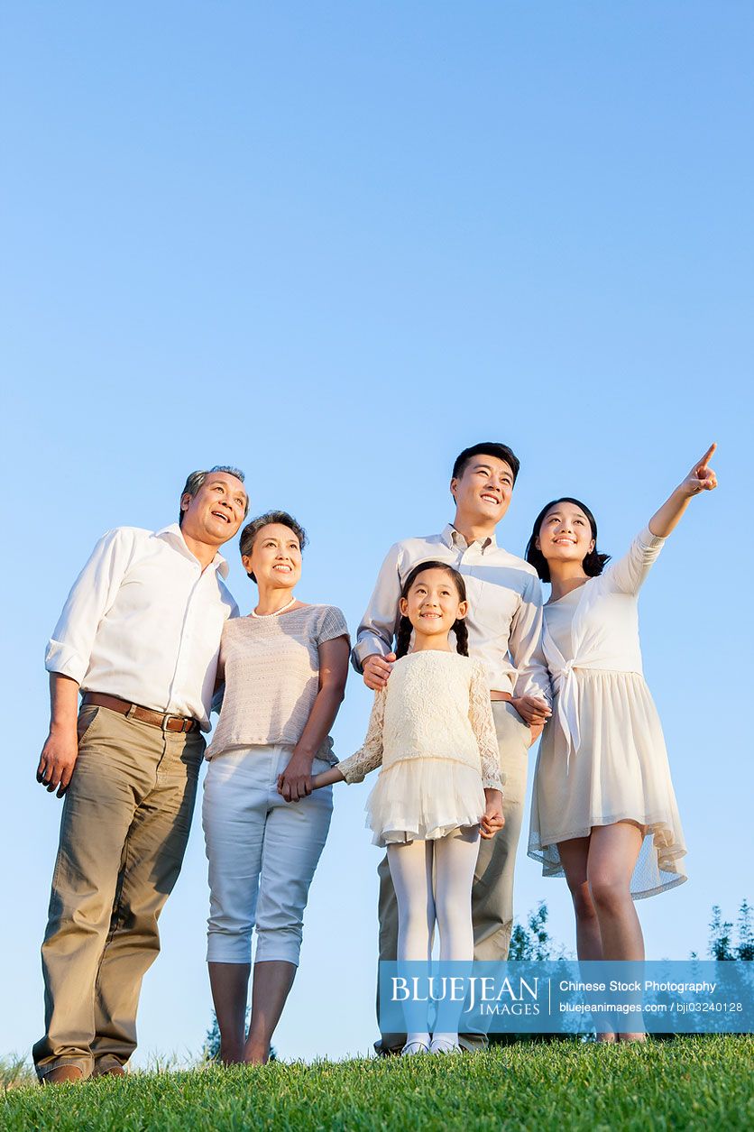 Cheerful Chinese family looking at view in a park