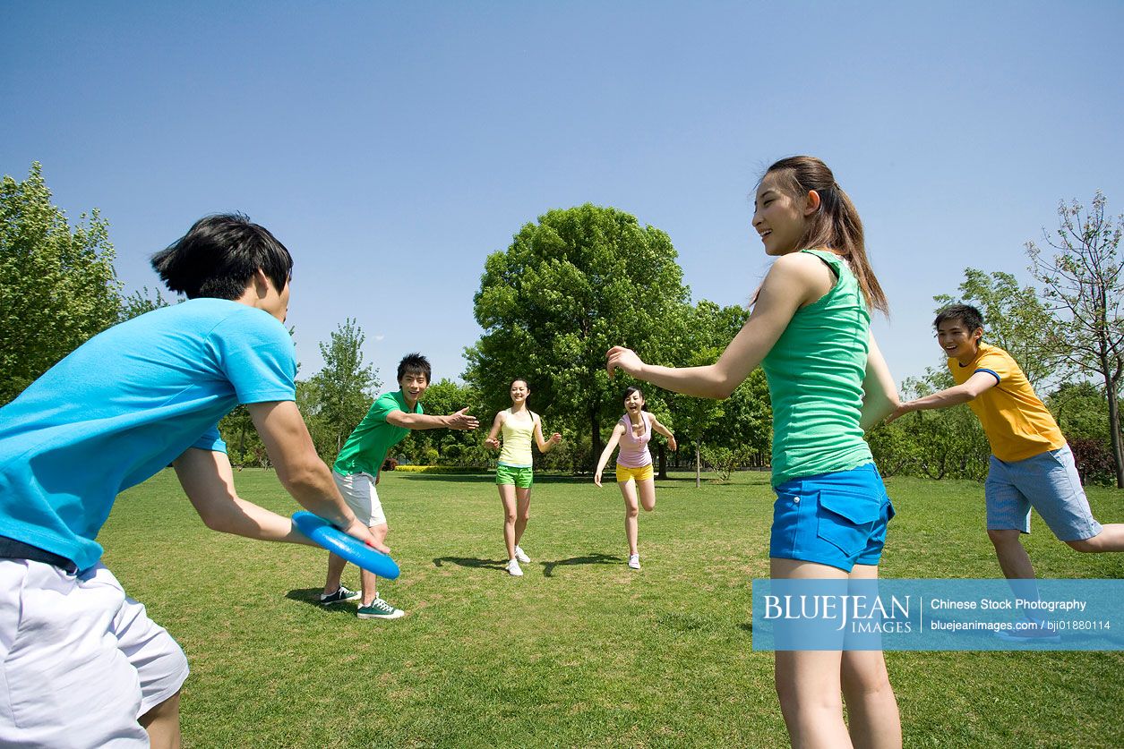 A group of Chinese friends playing with a Frisbee