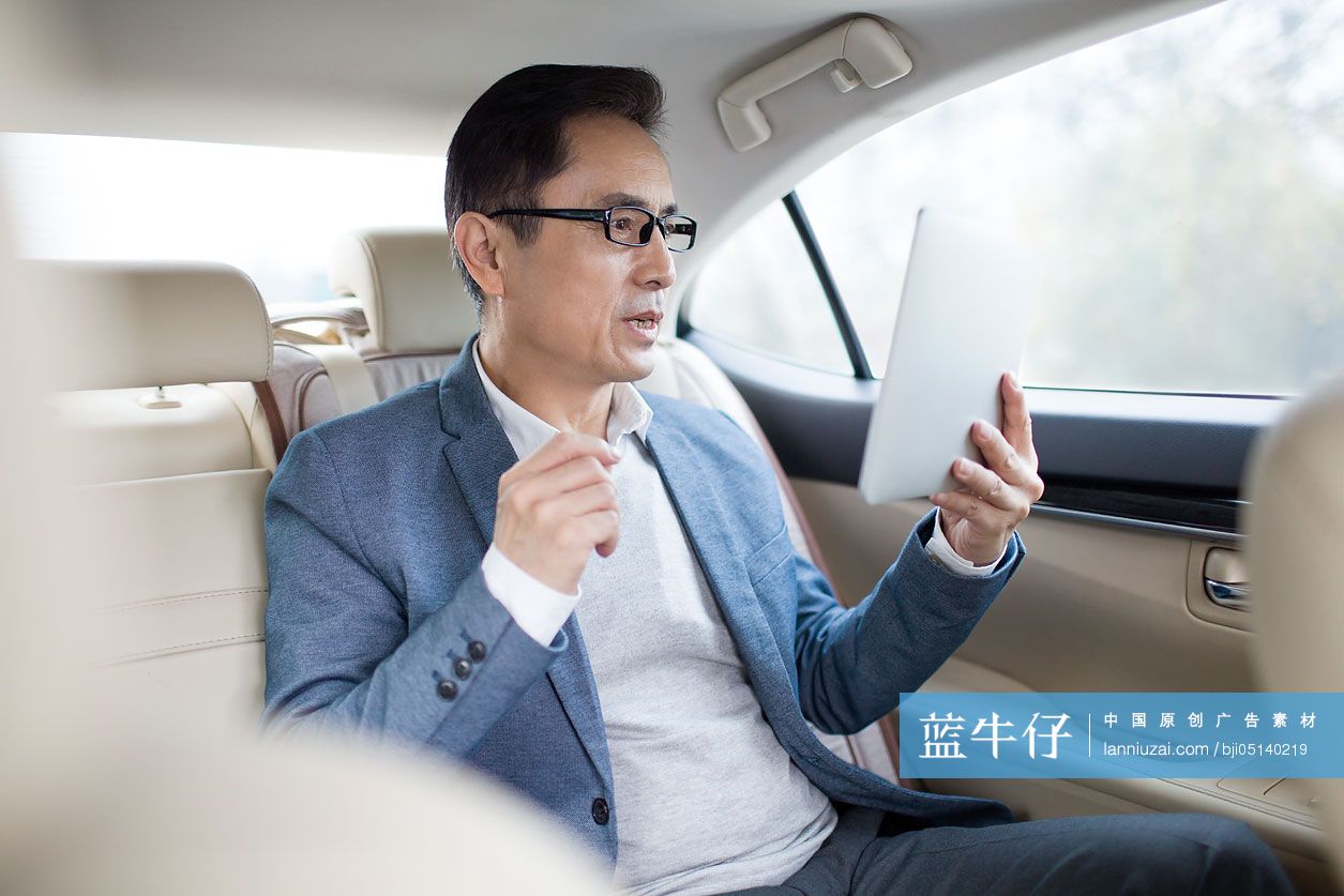 商务男士在车内使用平板电脑