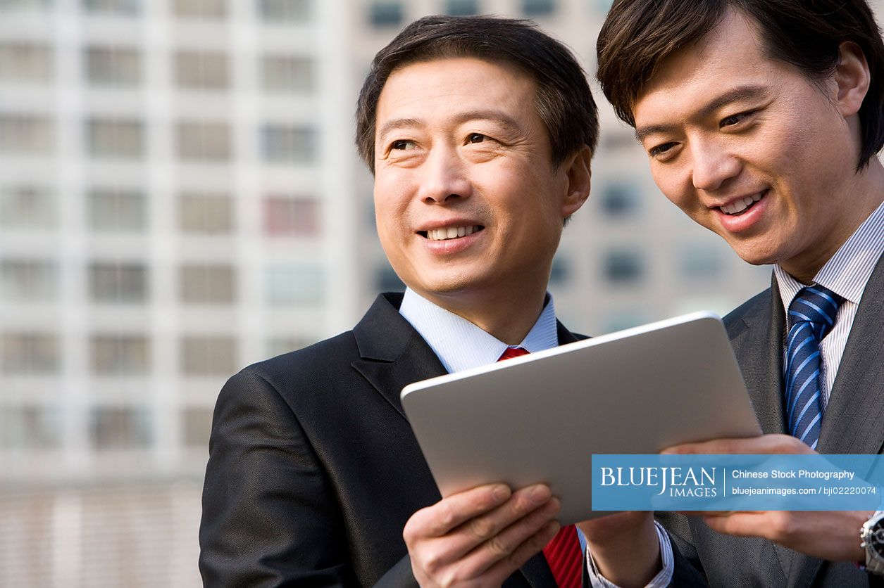 Chinese business partners using a tablet together