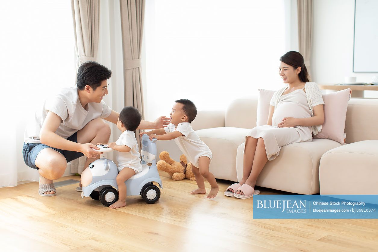 Happy young Chinese family playing at home