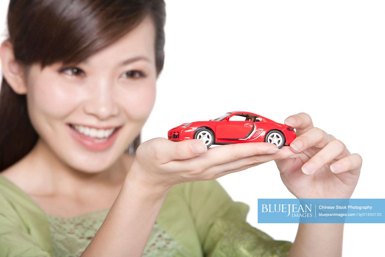 Portrait of young Chinese woman with toy car