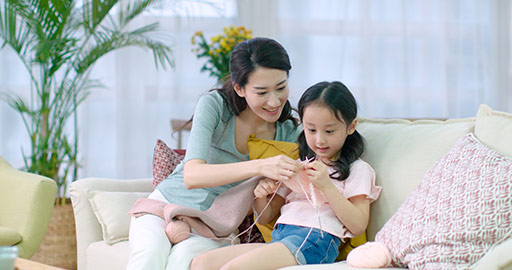 Happy Chinese mother and daughter knitting at home,4K
