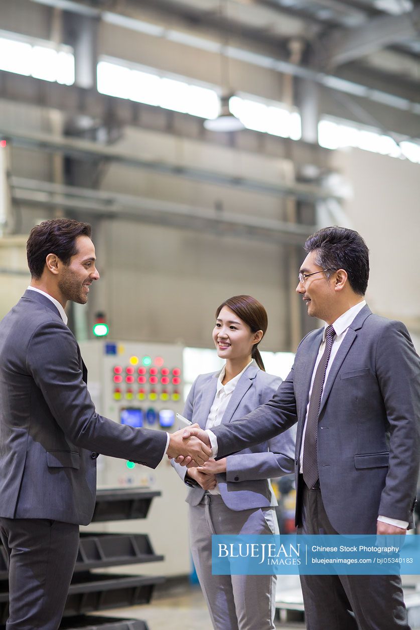 Business people shaking hands in the factory