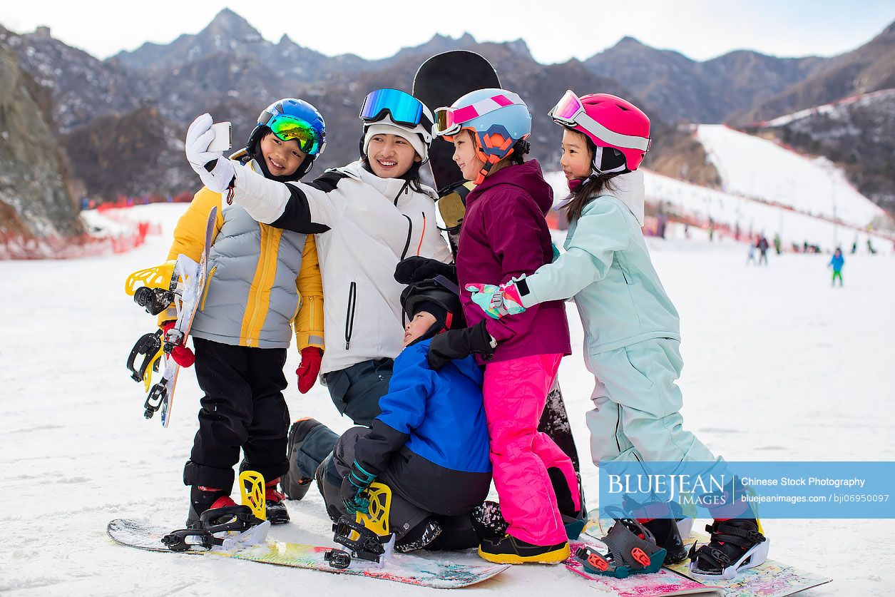 Cheerful Chinese children with their coach in ski resort