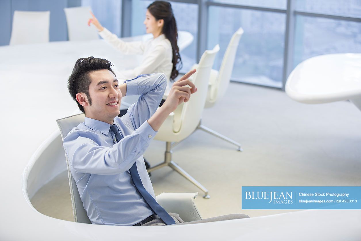 Chinese businessman using advanced touch screen technology in office