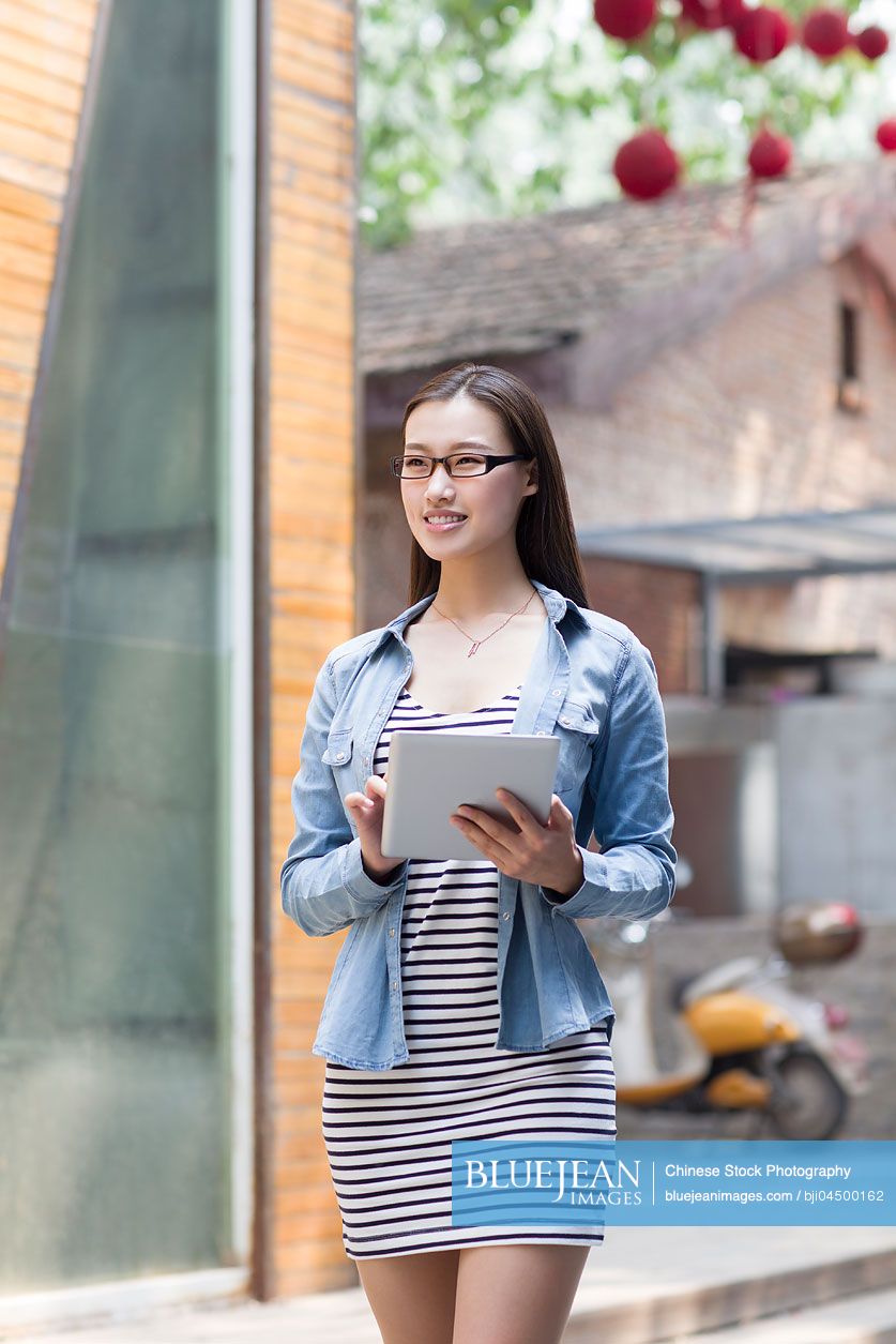 Young Chinese woman holding a digital tablet