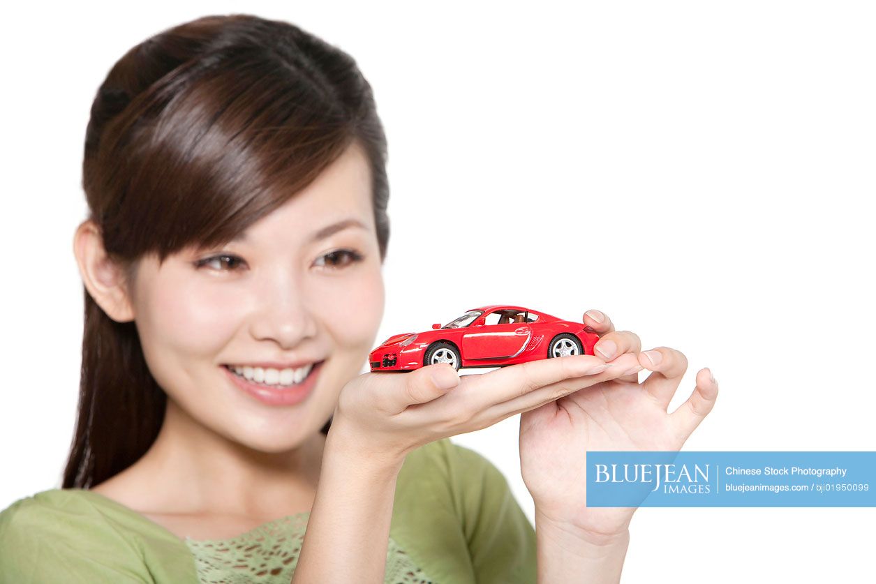 Portrait of young Chinese woman with toy car