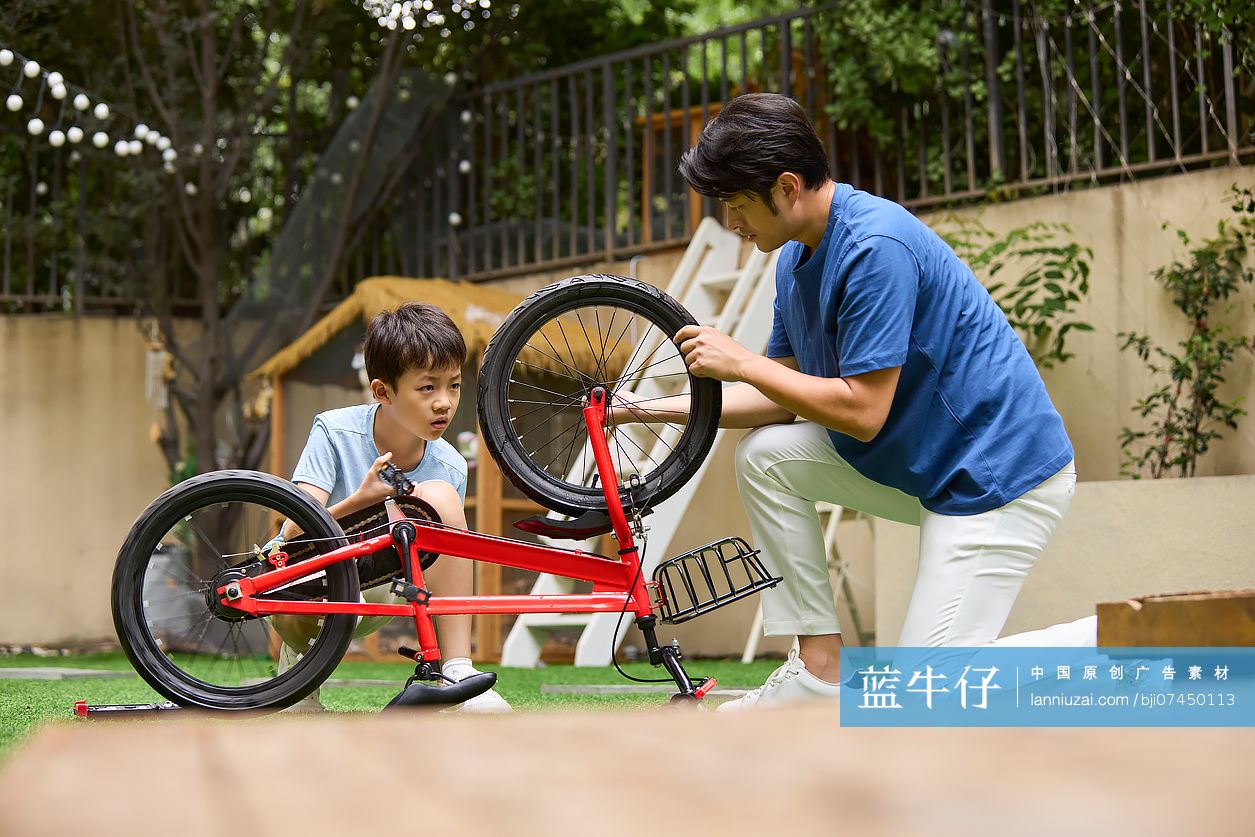 父子俩在院子里修自行车