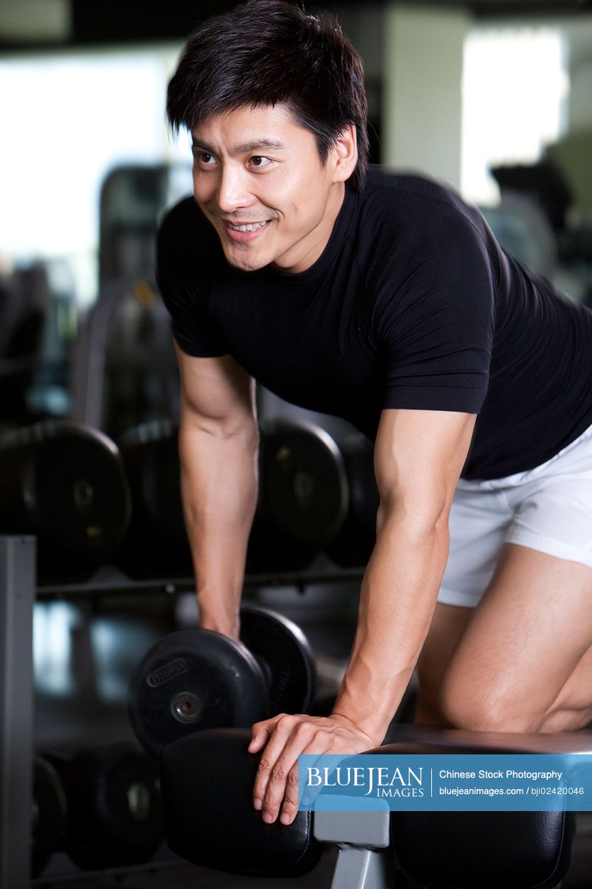 Mid-adult Chinese man lifting weights