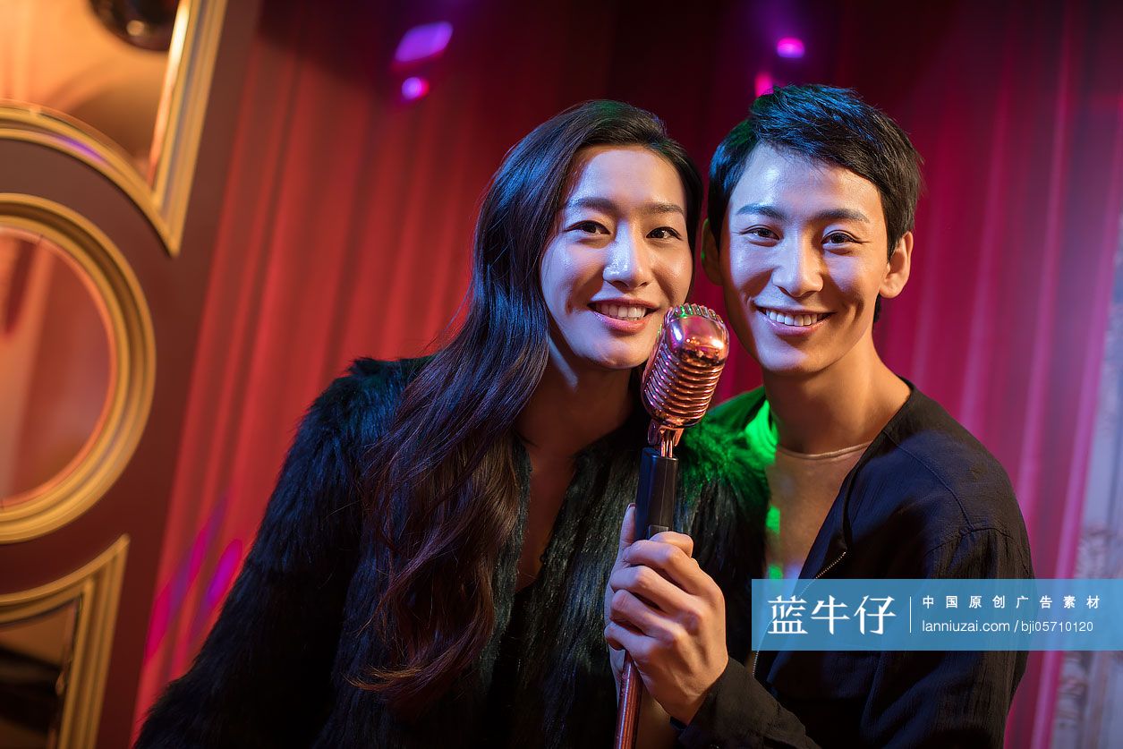 快乐的年轻情侣在KTV唱歌
