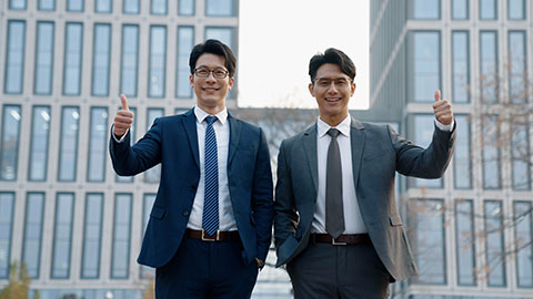 Confident Chinese businessmen doing thumbs-up