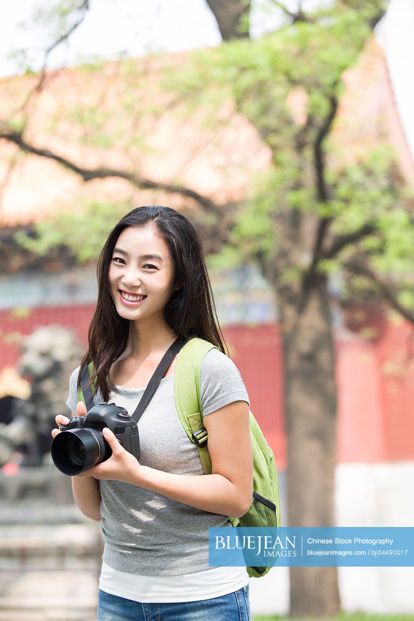 Young Chinese woman travelling at the Lama Temple with camera