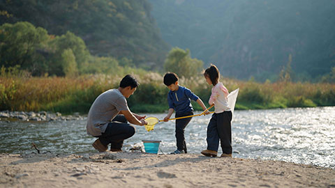 Happy young Chinese family having fun outdoors