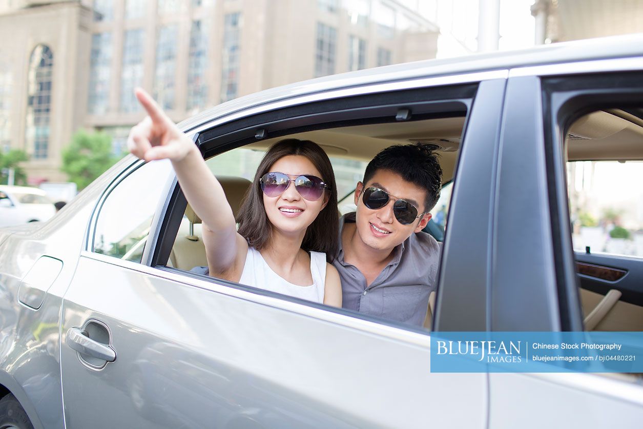 Happy young Chinese couple in a car