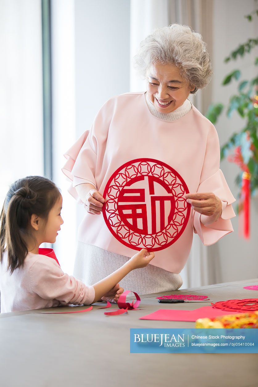 Granddaughter and grandmother with Chinese New Year paper-cut