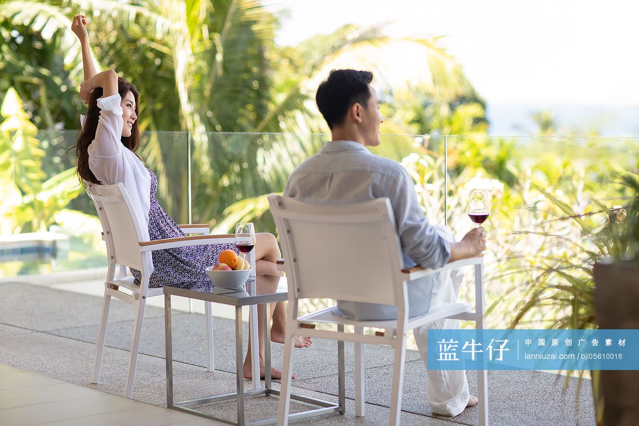 年轻夫妇在露台喝红酒