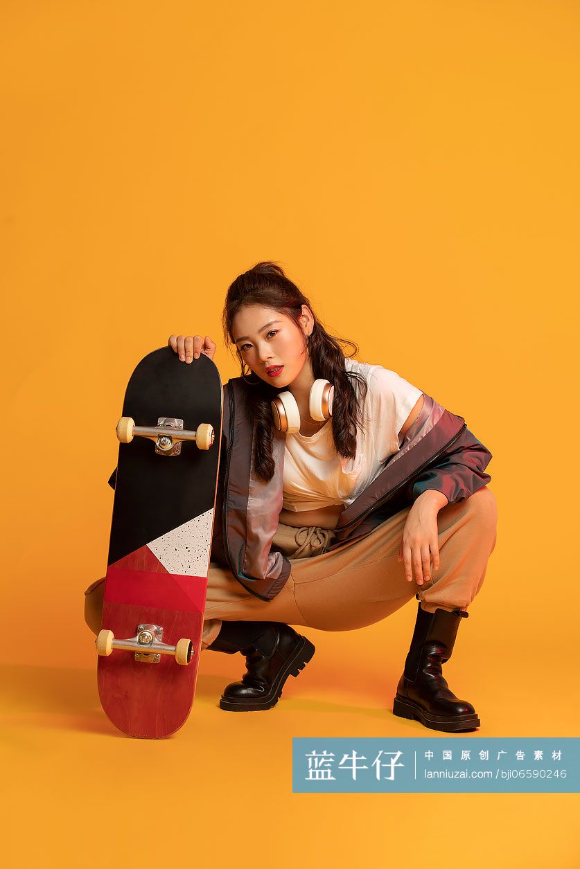时尚的年轻女孩拿着滑板