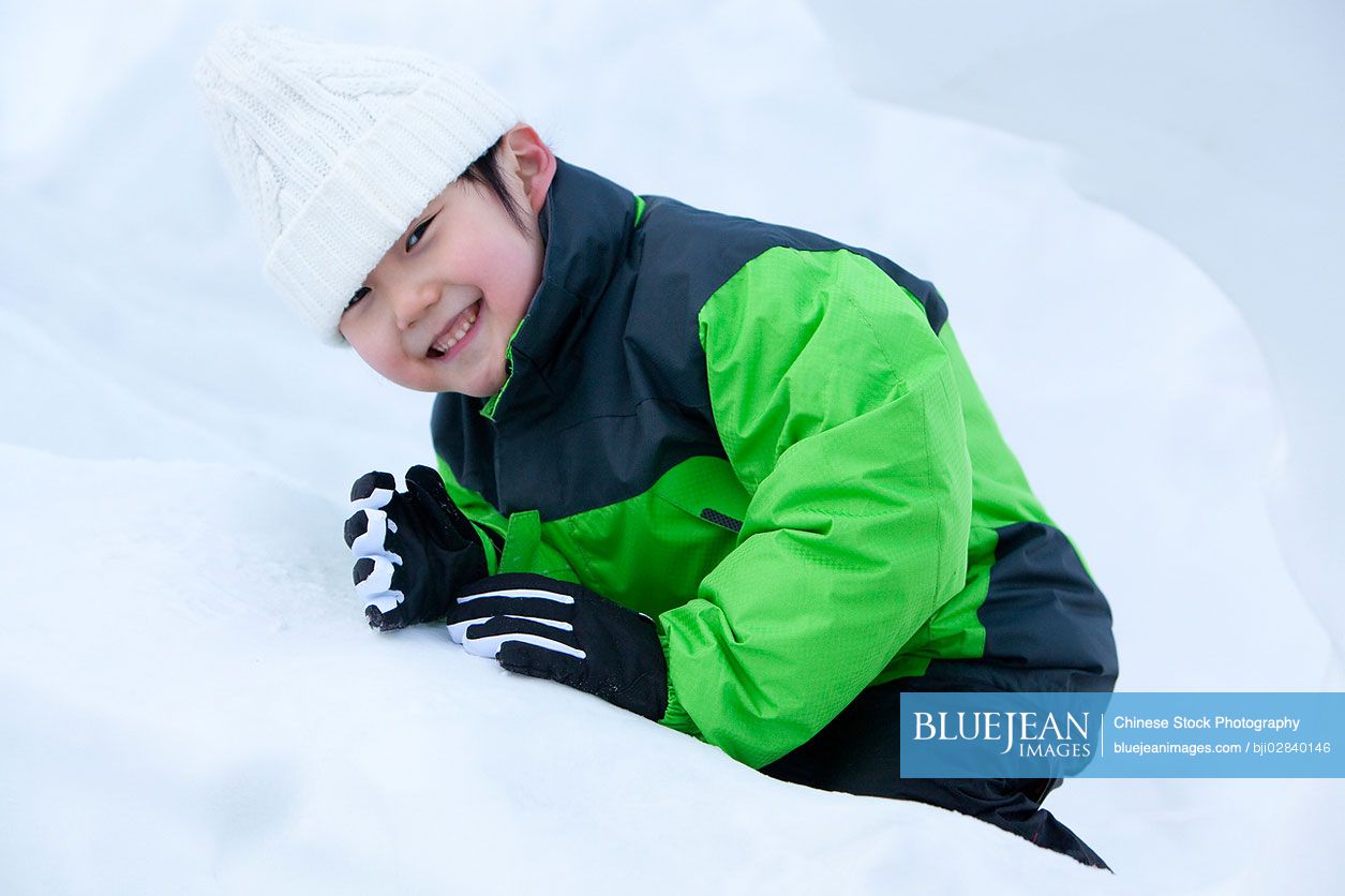 Cute Chinese boy having fun in snow