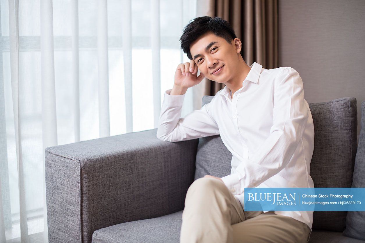 Young Chinese man relaxing on sofa