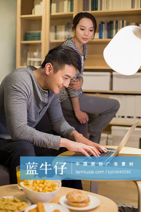 年轻情侣在客厅使用笔记本电脑-蓝牛仔影像-中国原创广告影像素材