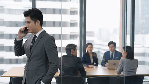 Young Chinese businessman talking on cell phone in office,4K