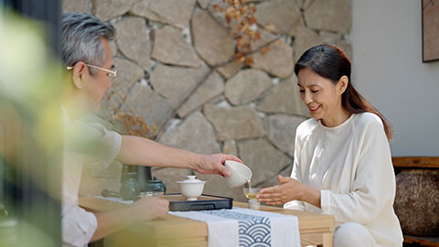 Happy mature Chinese couple drinking tea in tea room,4K