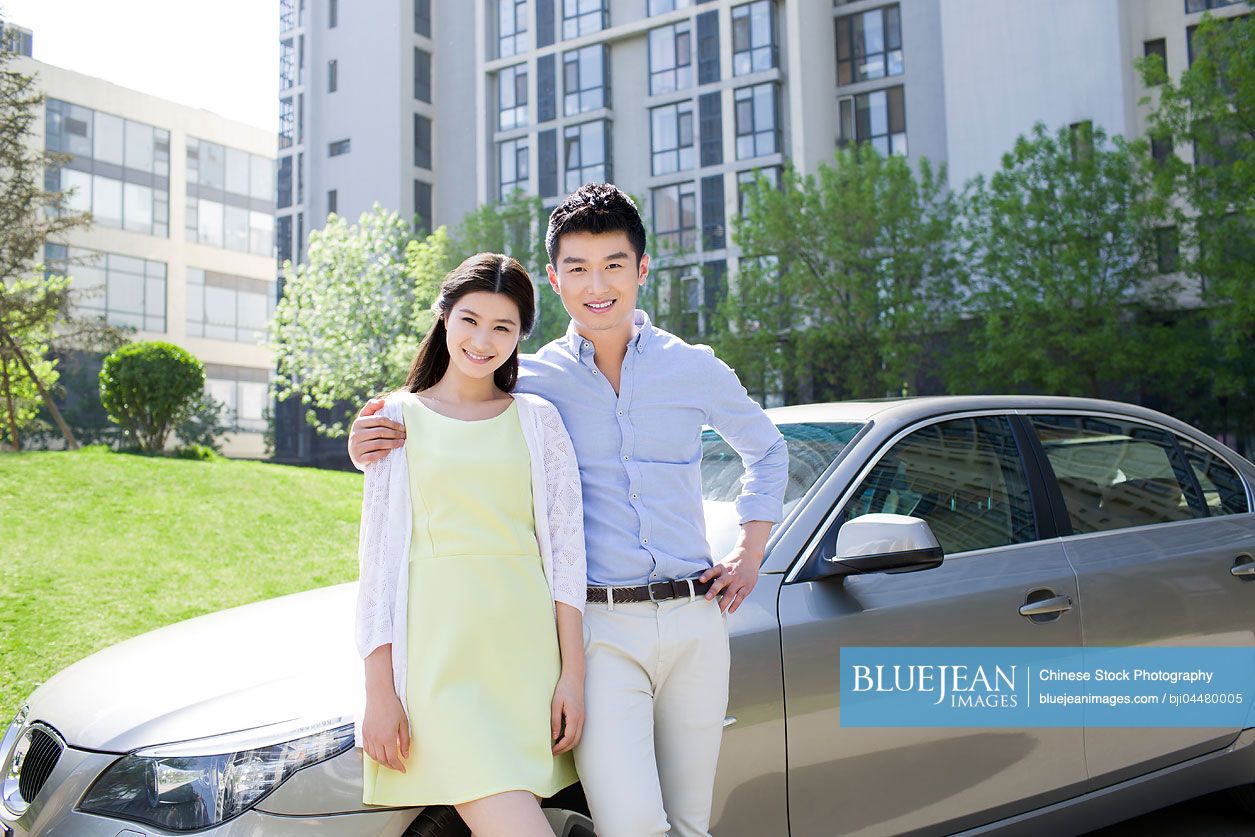 Happy young Chinese couple and car