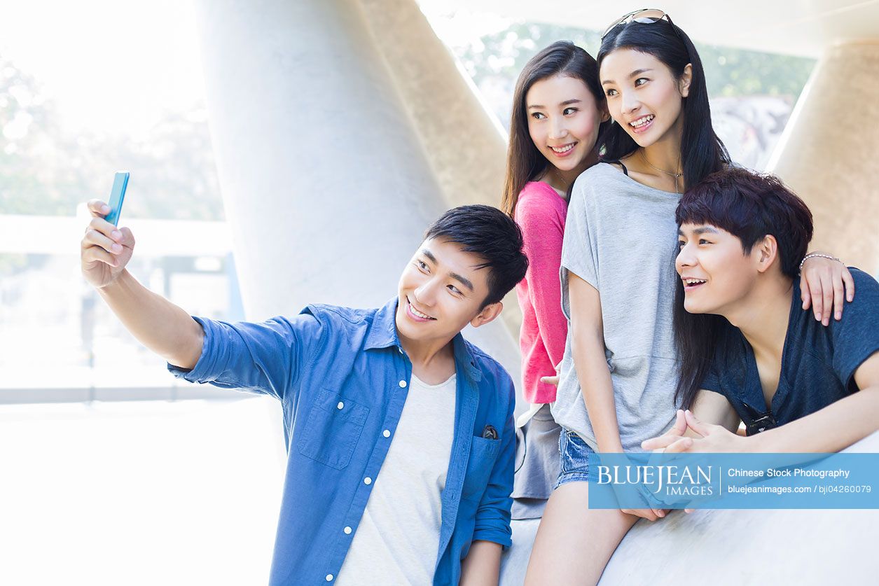 Young Chinese friends taking self portrait with a smart phone