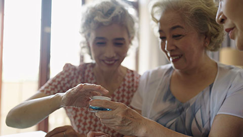 Senior Chinese friends applying moisturizer at home,4K