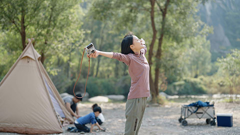 Happy young Chinese family camping outdoors