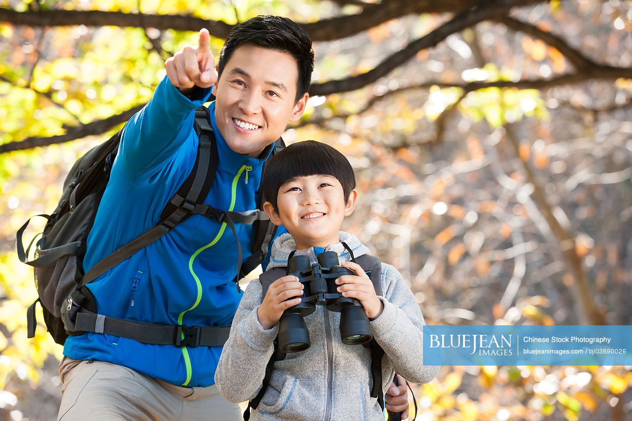 Cheerful Chinese father and son hiking