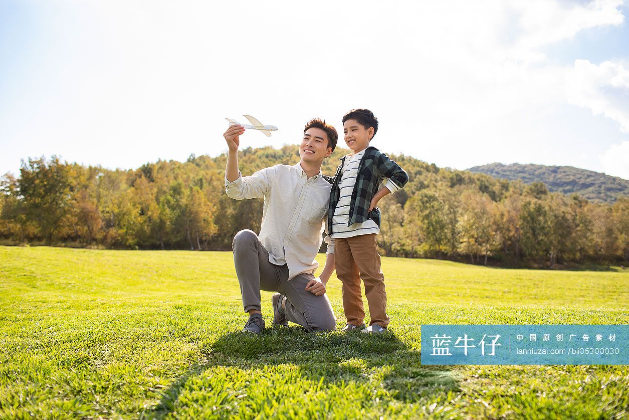 快乐的的父子俩在草地上玩耍