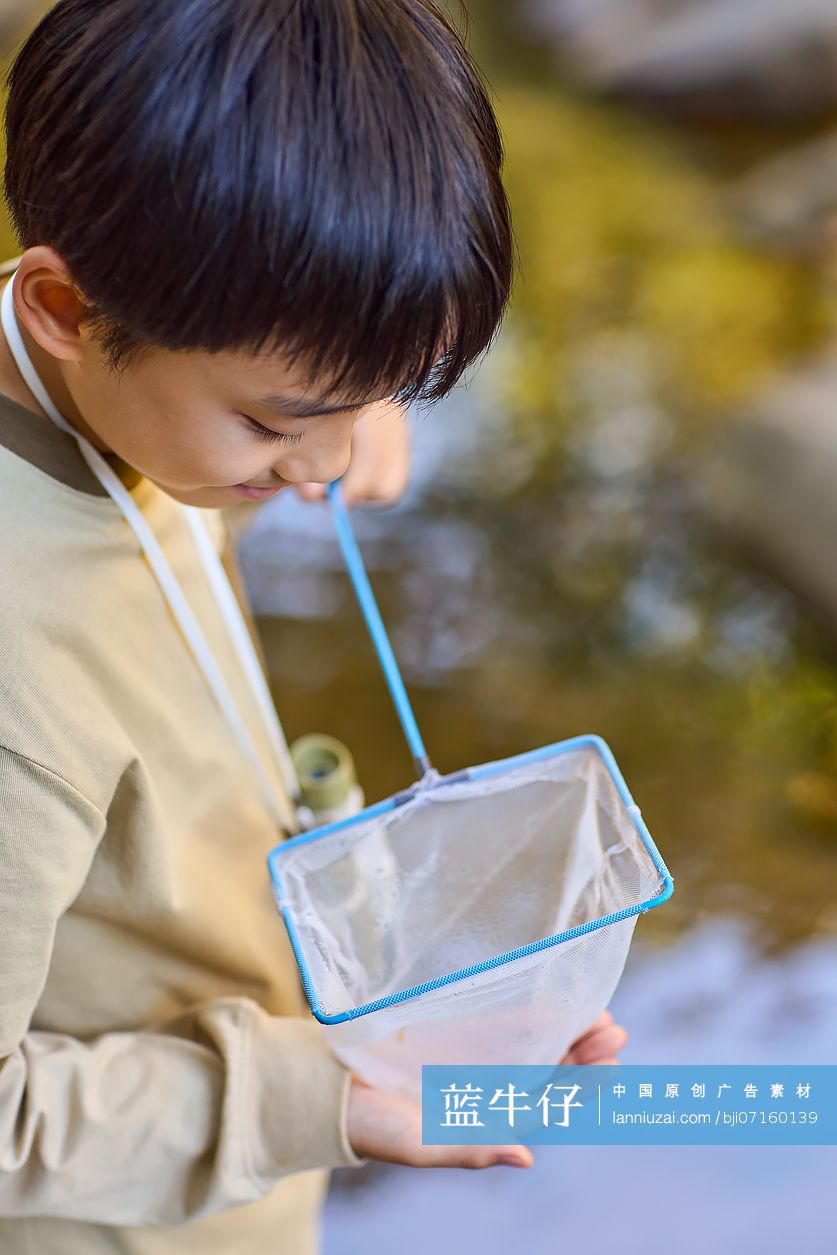 男孩在小溪边捞鱼
