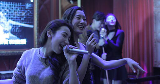 Happy young Chinese friends singing karaoke in nightclub,4k