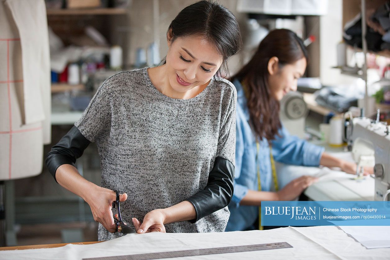 Two Chinese fashion designers working in studio