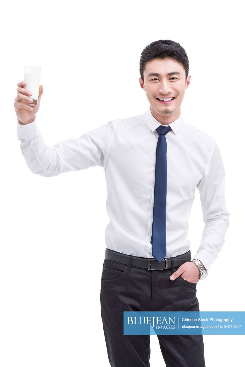 Happy young Chinese businessman with milk