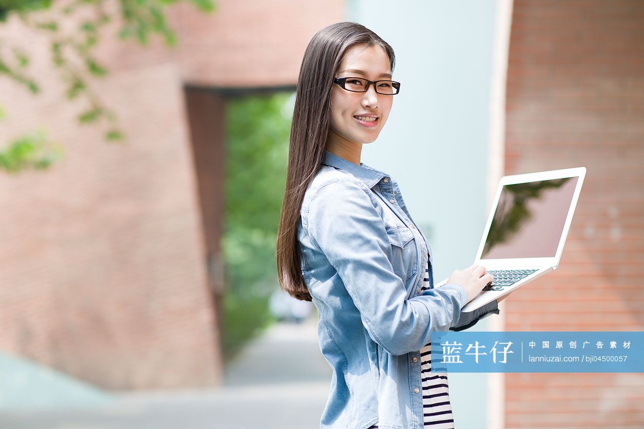 年轻女子拿着笔记本电脑