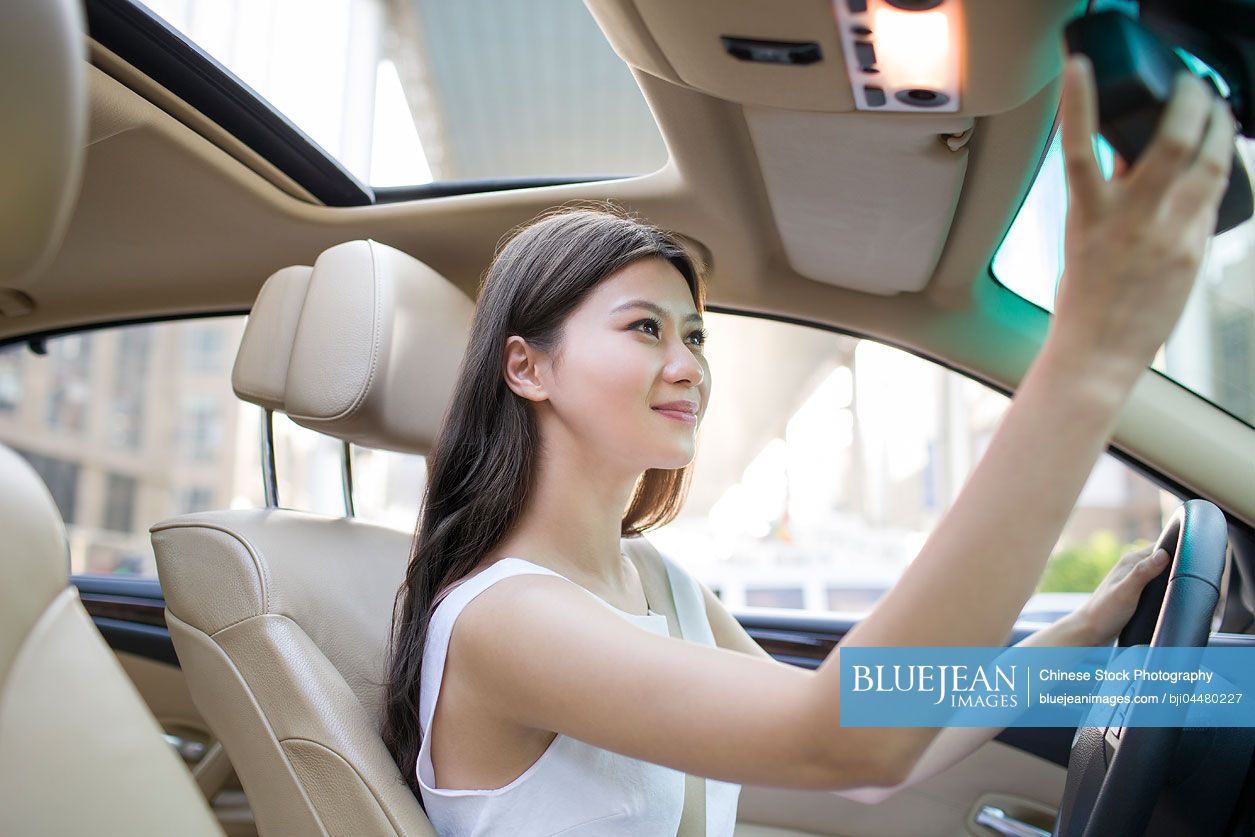 Young Chinese woman driving car